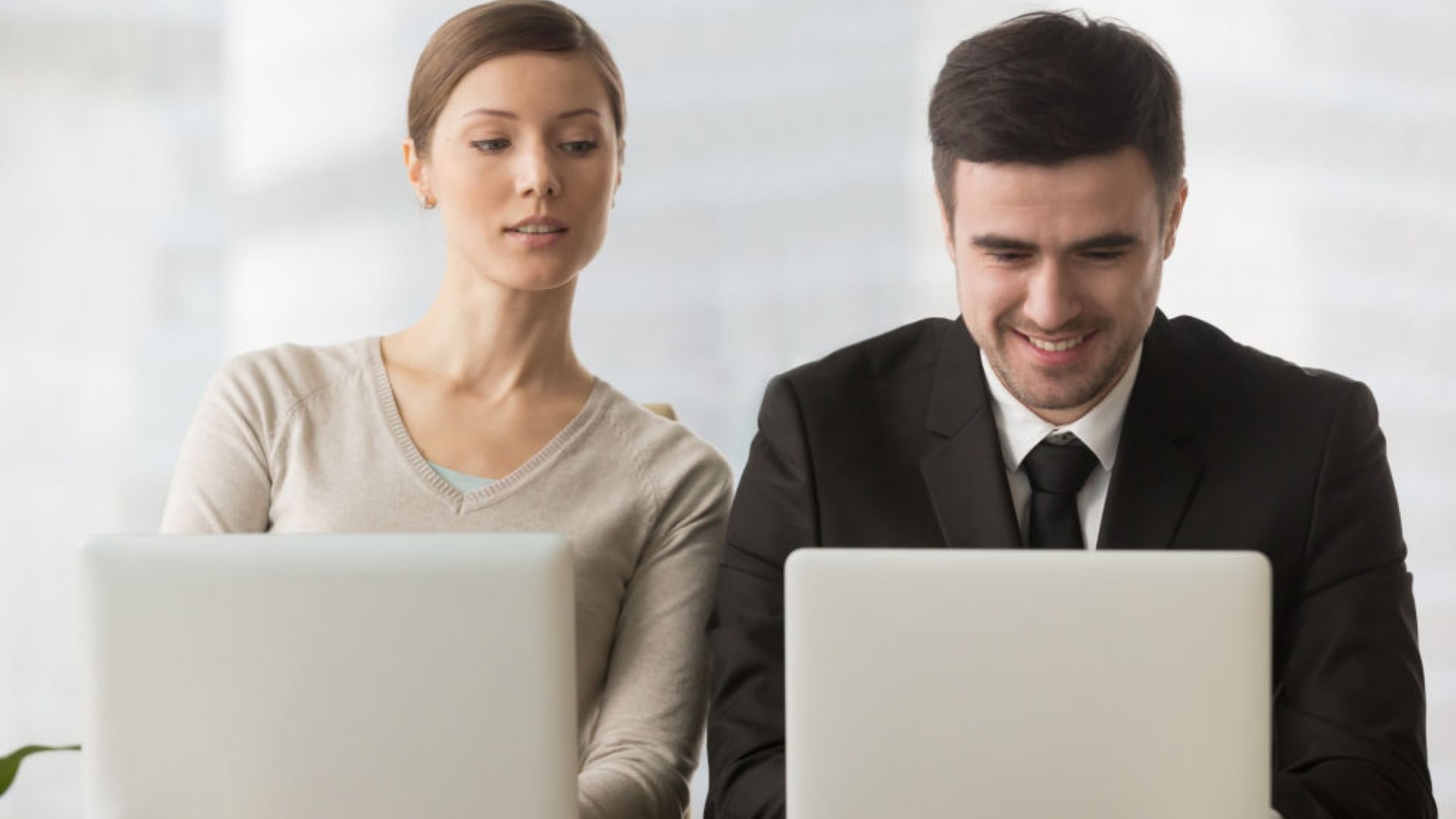 woman-peering-over-shoulder-of-coworker