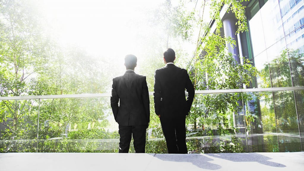 two-business-men-looking-over-green-city